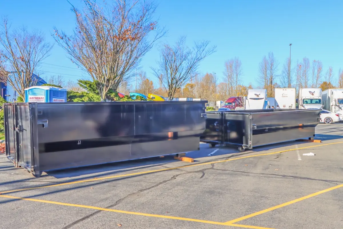 Professional dumpster rental service with roll-off container on residential driveway in Fenton